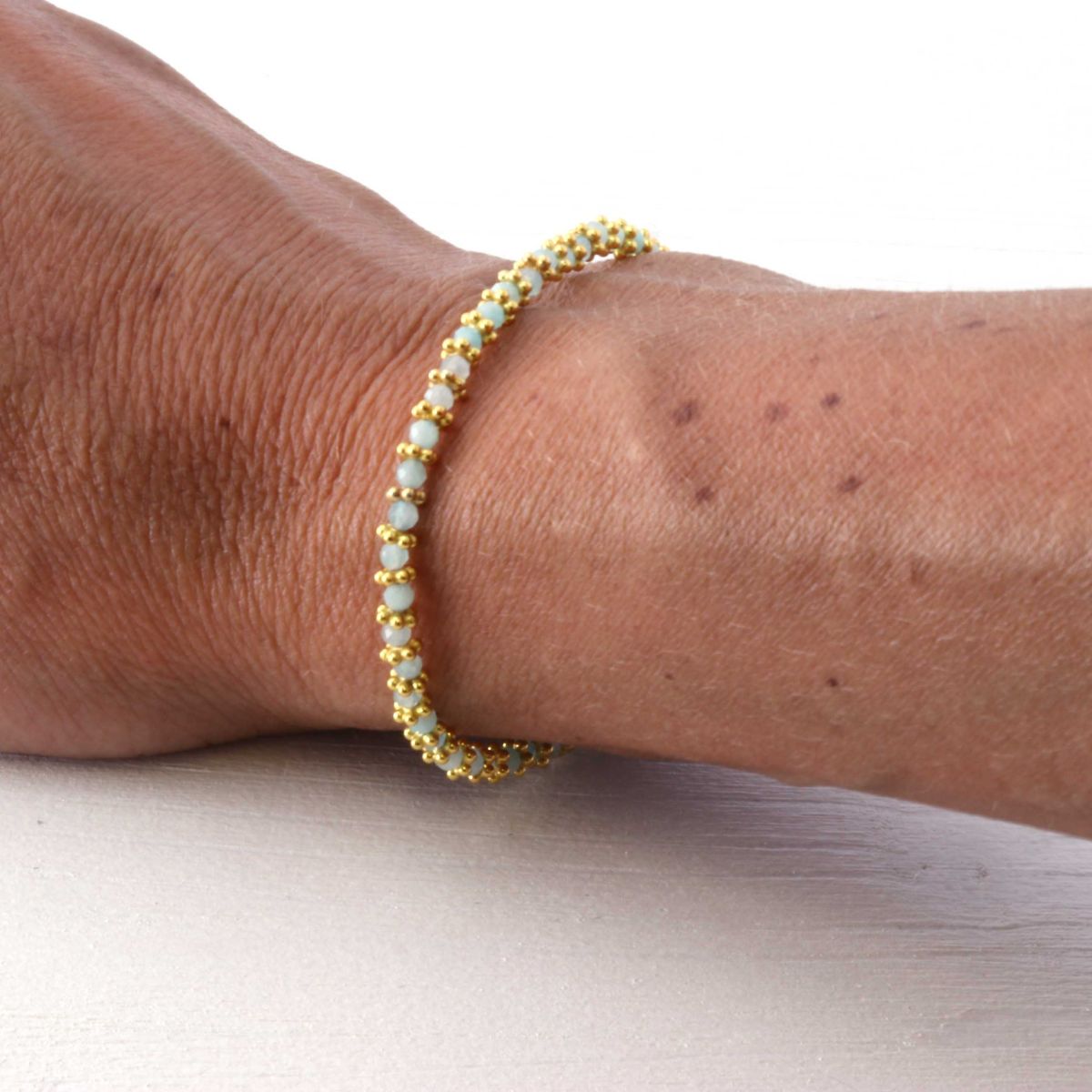 a woman wearing an amazonite bracelet on her wrist