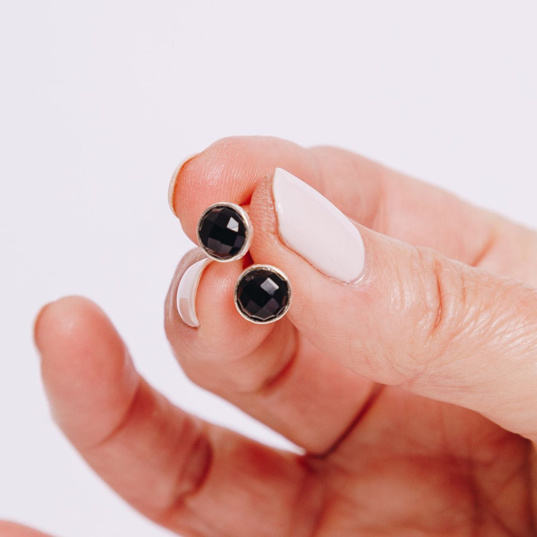 a woman holding two studs in her hand 