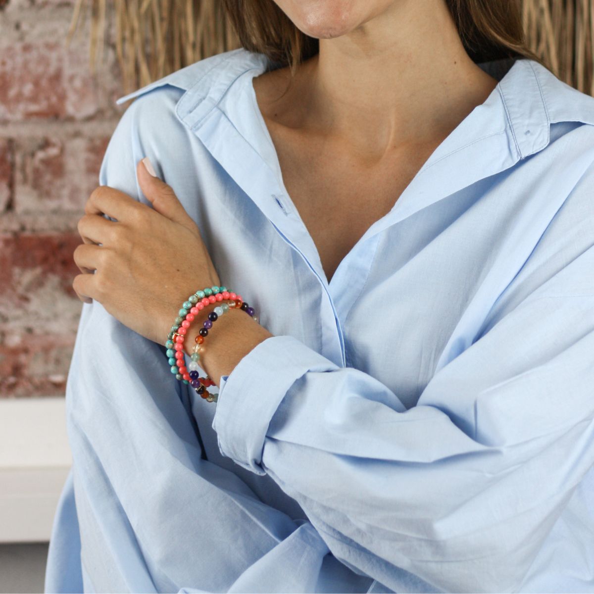 a woman wearing stacked bracelets on her wrist