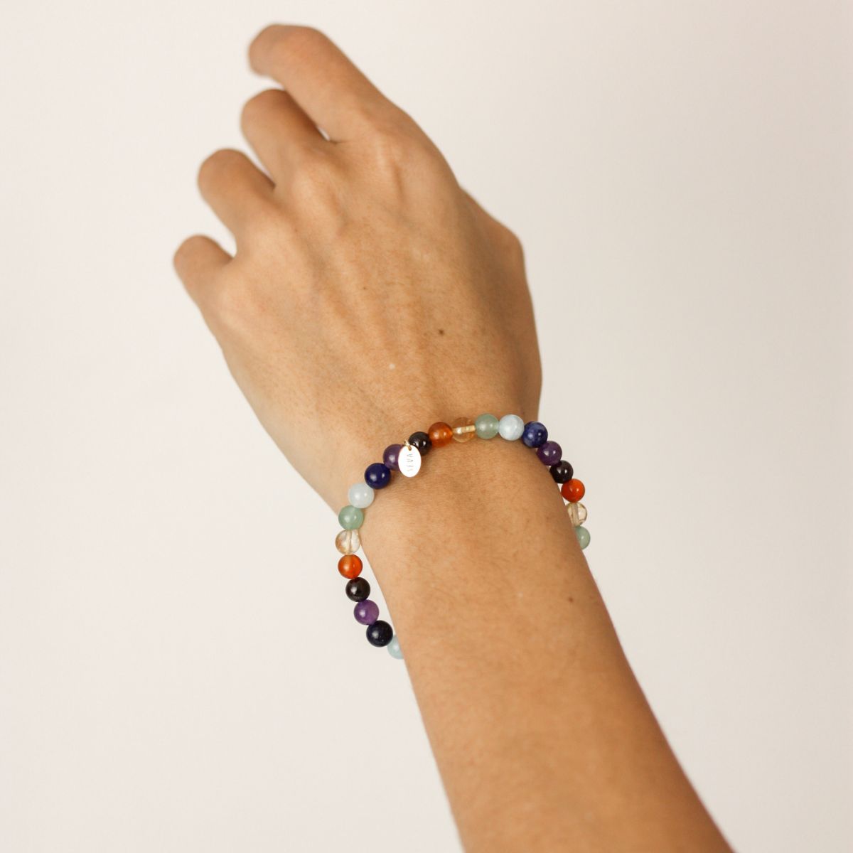 a woman wearing a chakra bracelet on her wrist 