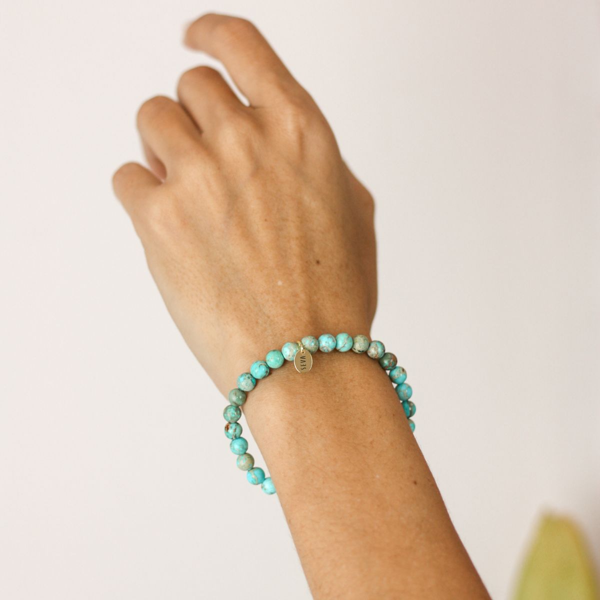 a woman wearing a stone bracelet on her wrist