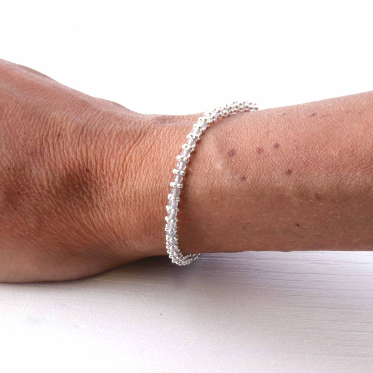 a woman wearing a silver labradorite bracelet on her wrist