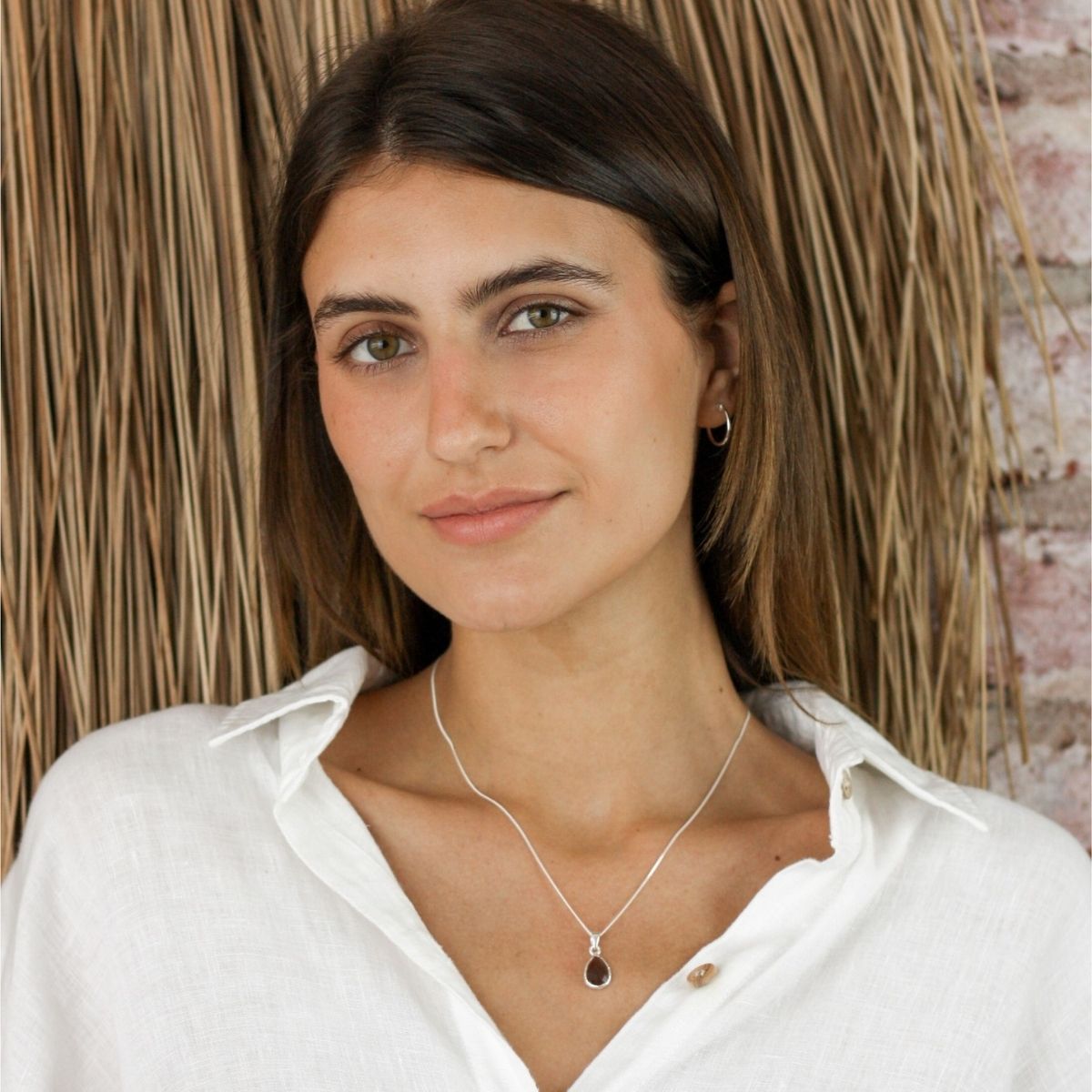 a woman wearing a pendant necklace around her neck
