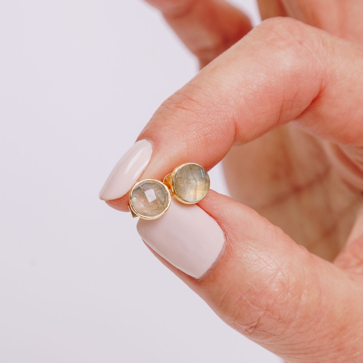 a woman holding studs in her fingers