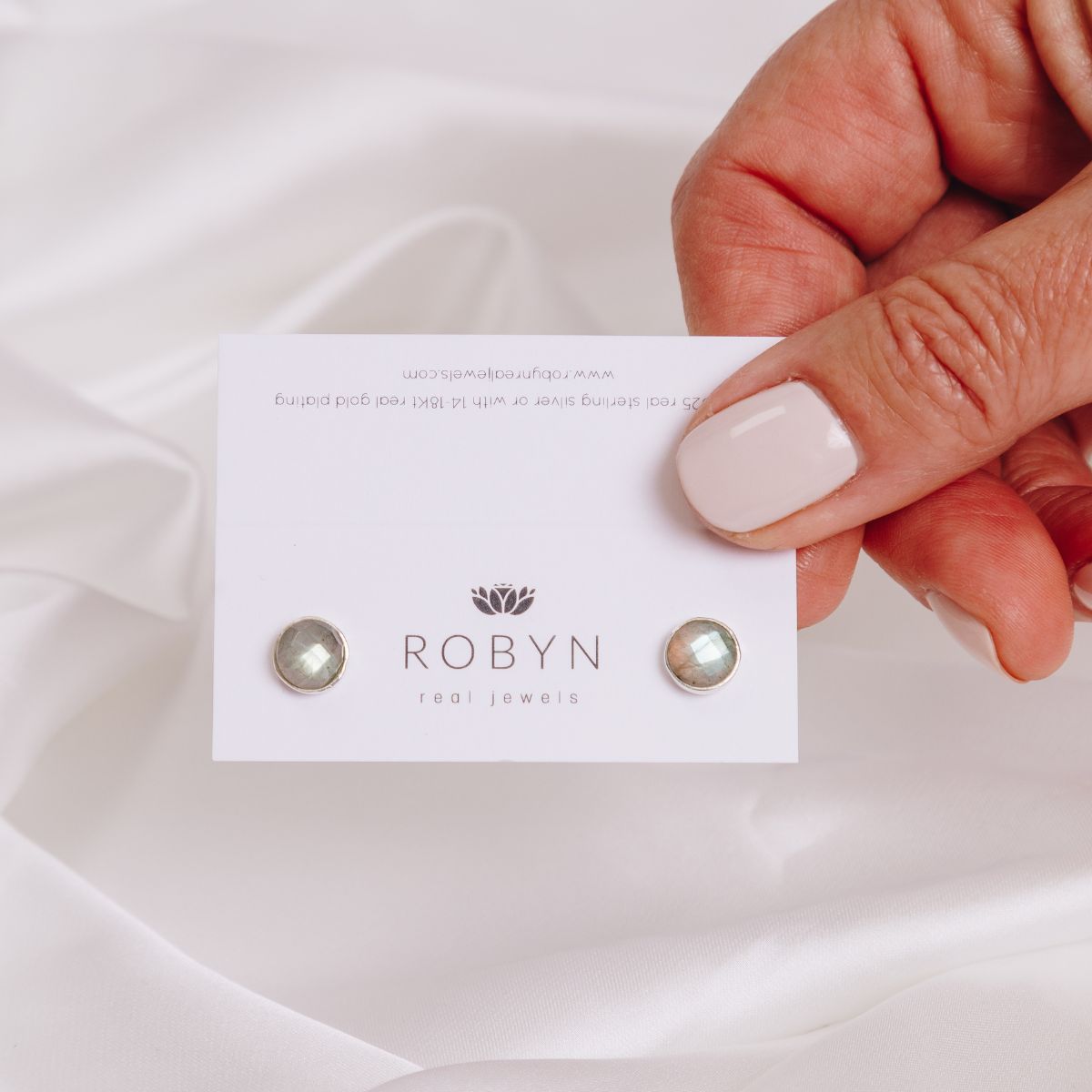 a woman holding earrings in her fingers