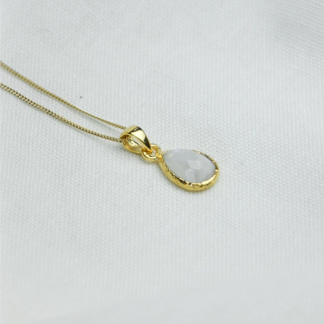 a white pendant necklace on a white cloth