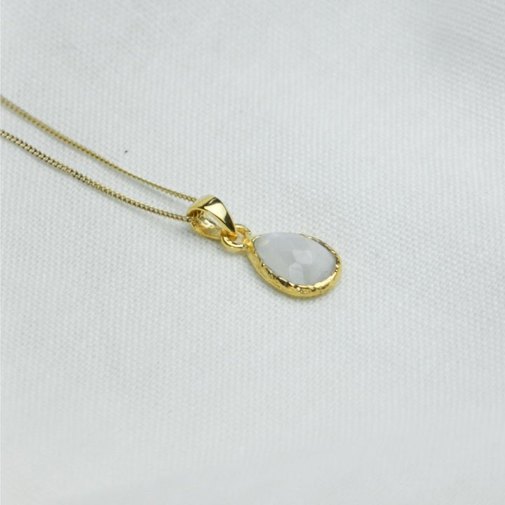 a white pendant necklace on a white cloth