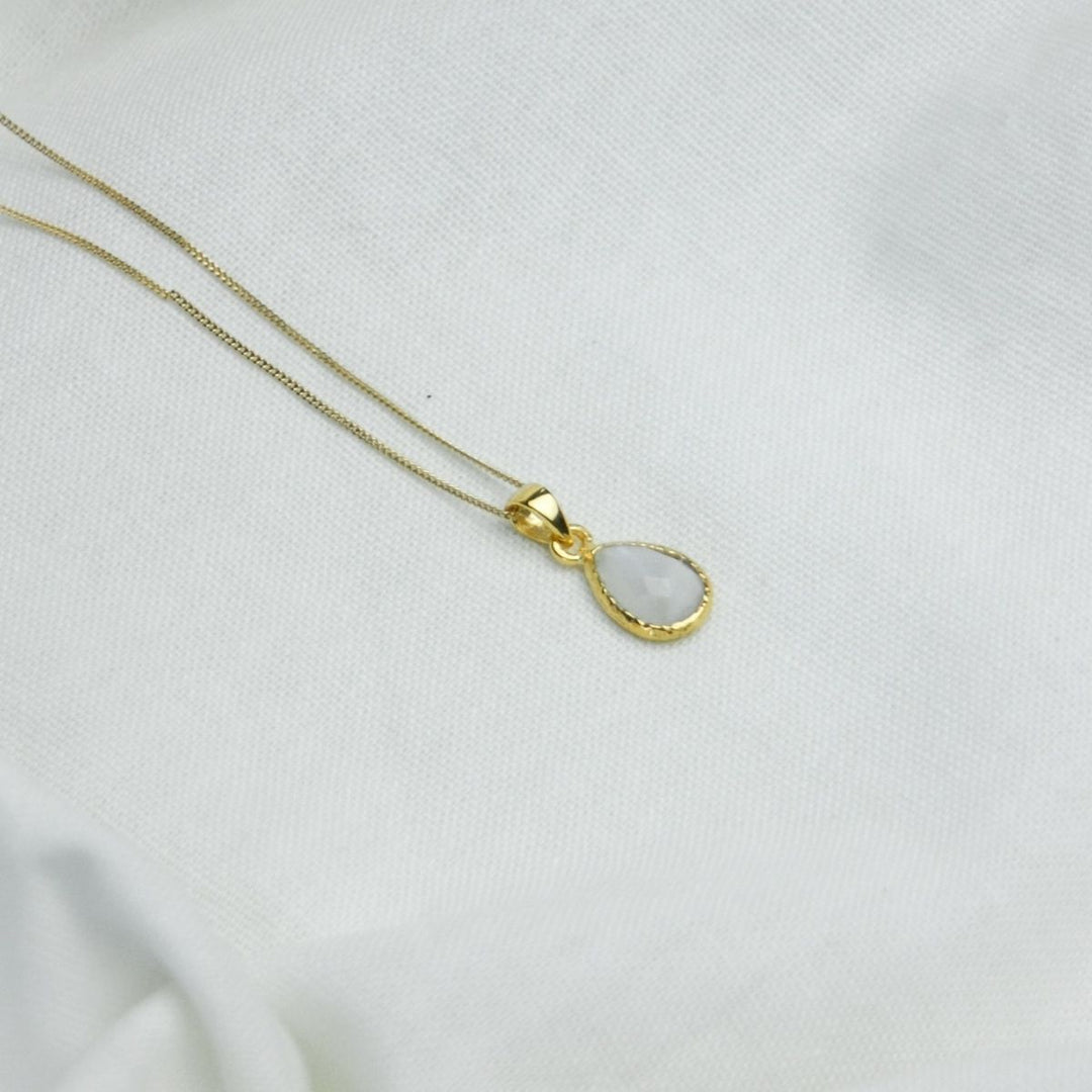 a white pendant necklace on a white cloth