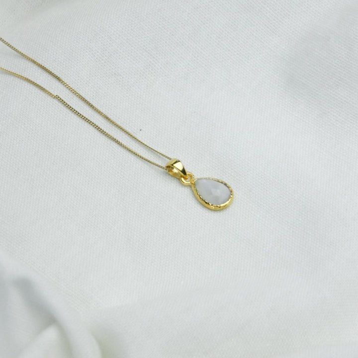 a white pendant necklace on a white cloth