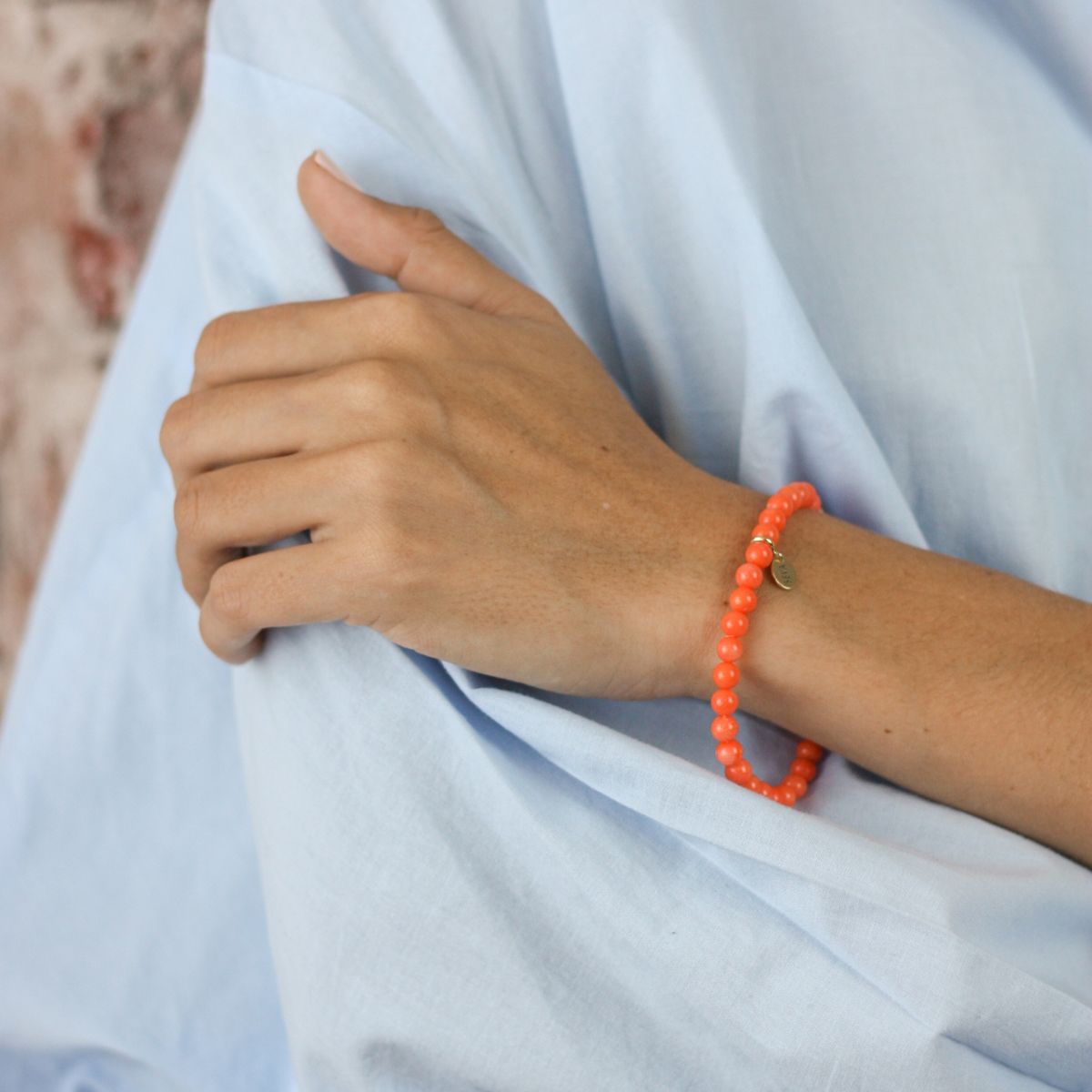 a woman wearing a stone bracelet on her wrist
