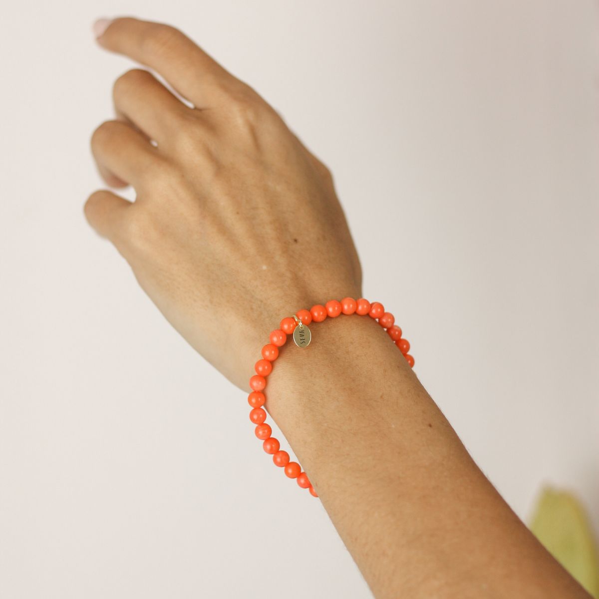 a woman wearing a stone bracelet on her wrist