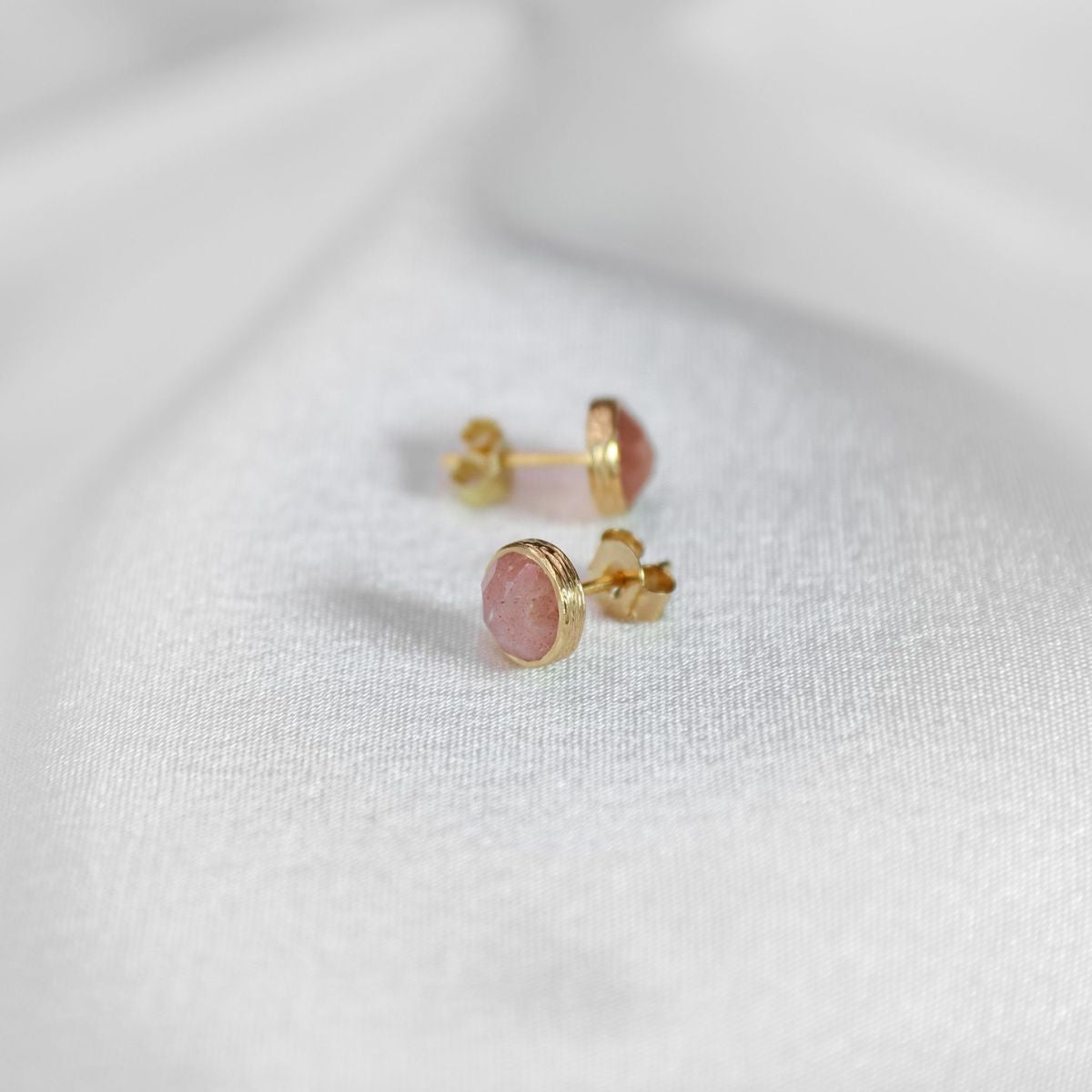 a pair of studs on a white cloth