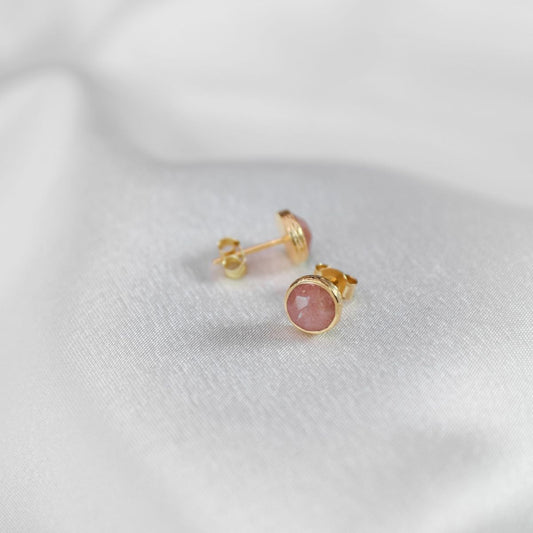 a pair of peach moonstone studs on a white cloth