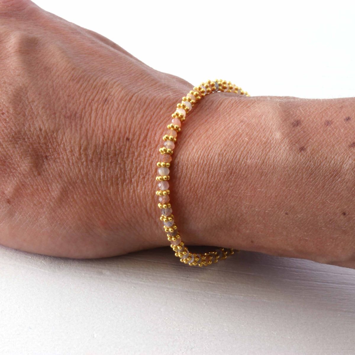 peach moonstone bracelet on a woman's wrist