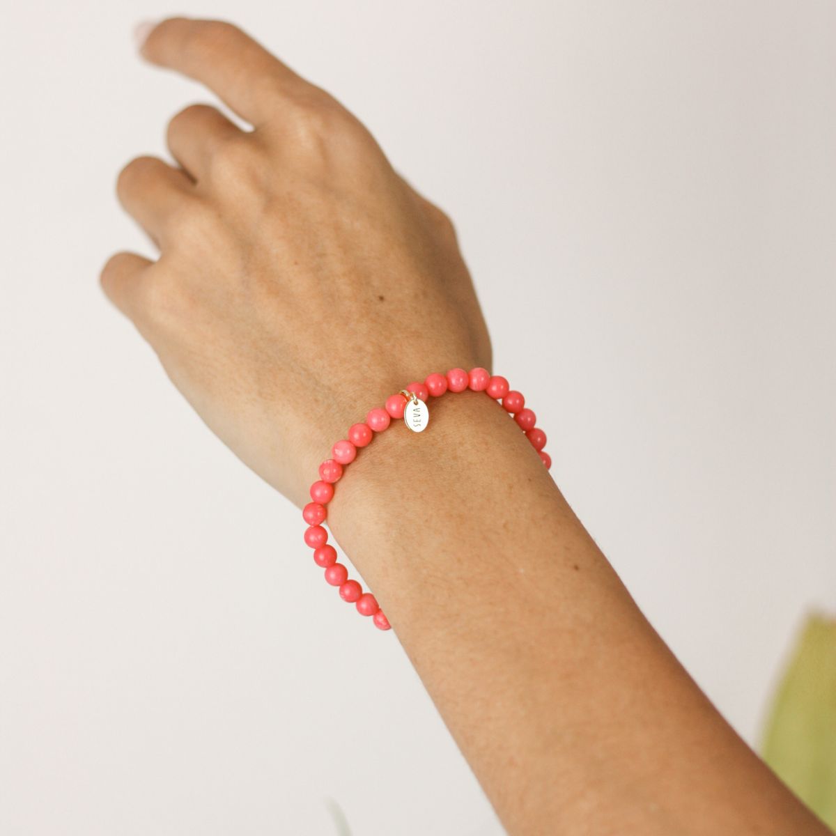 a woman wearing a stone bracelet on her wrist