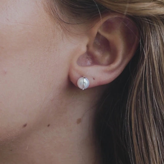a woman wearing pearl earrings in her ears
