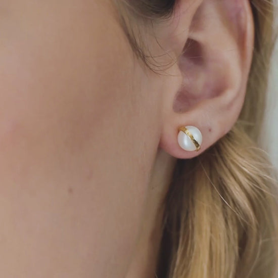 a woman wearing pearl earrings in the ear