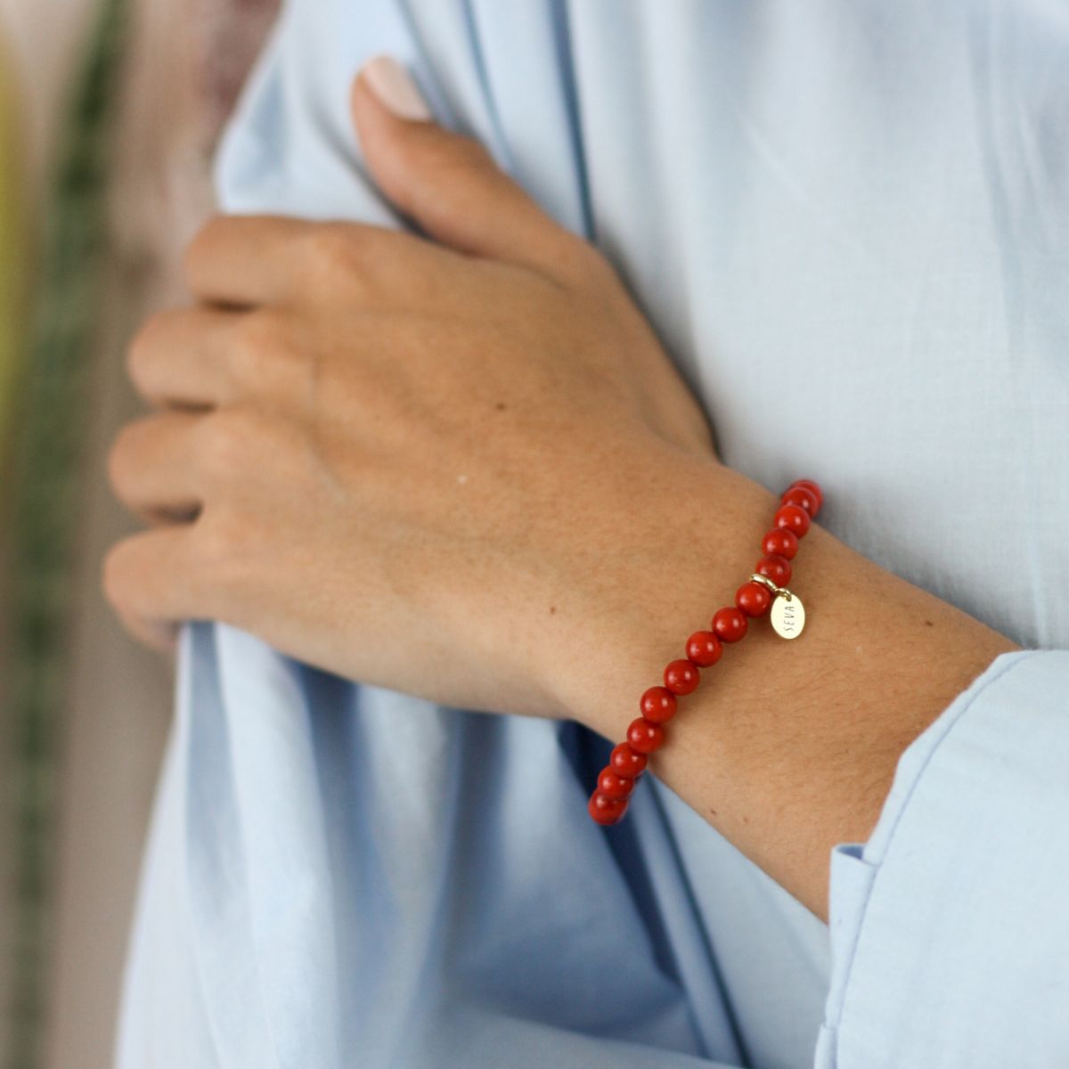 a woman wearing a stone bracelet on her wrist