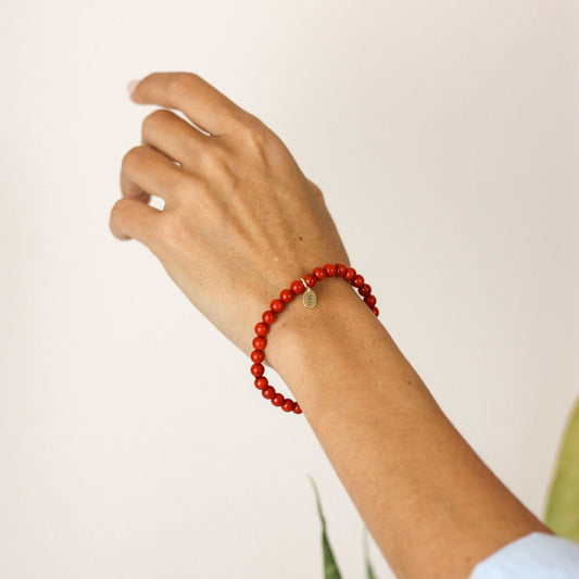 a woman wearing a stone bracelet on her wrist