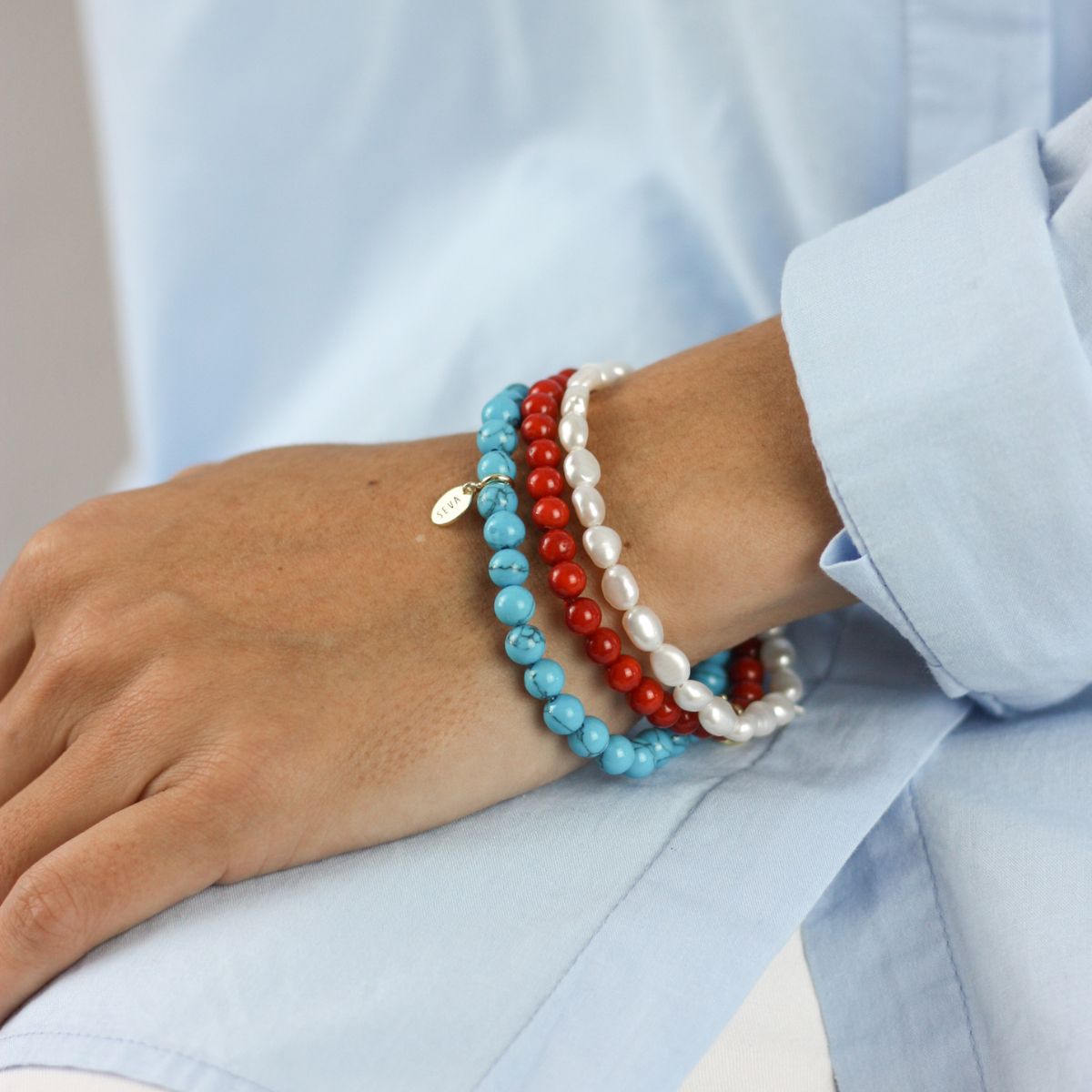 a woman wearing stacked bracelet on her arm