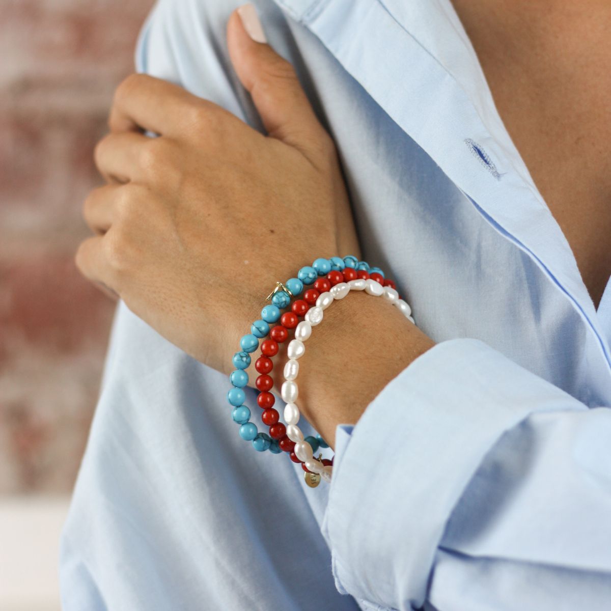 a woman wearing stacked bracelets on her wrist 