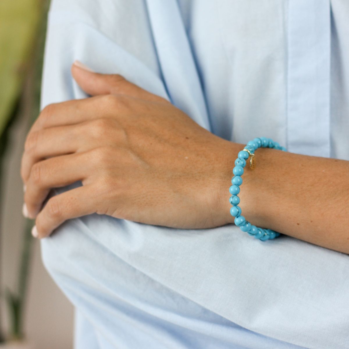 a woman wearing a stone bracelet on her wrist