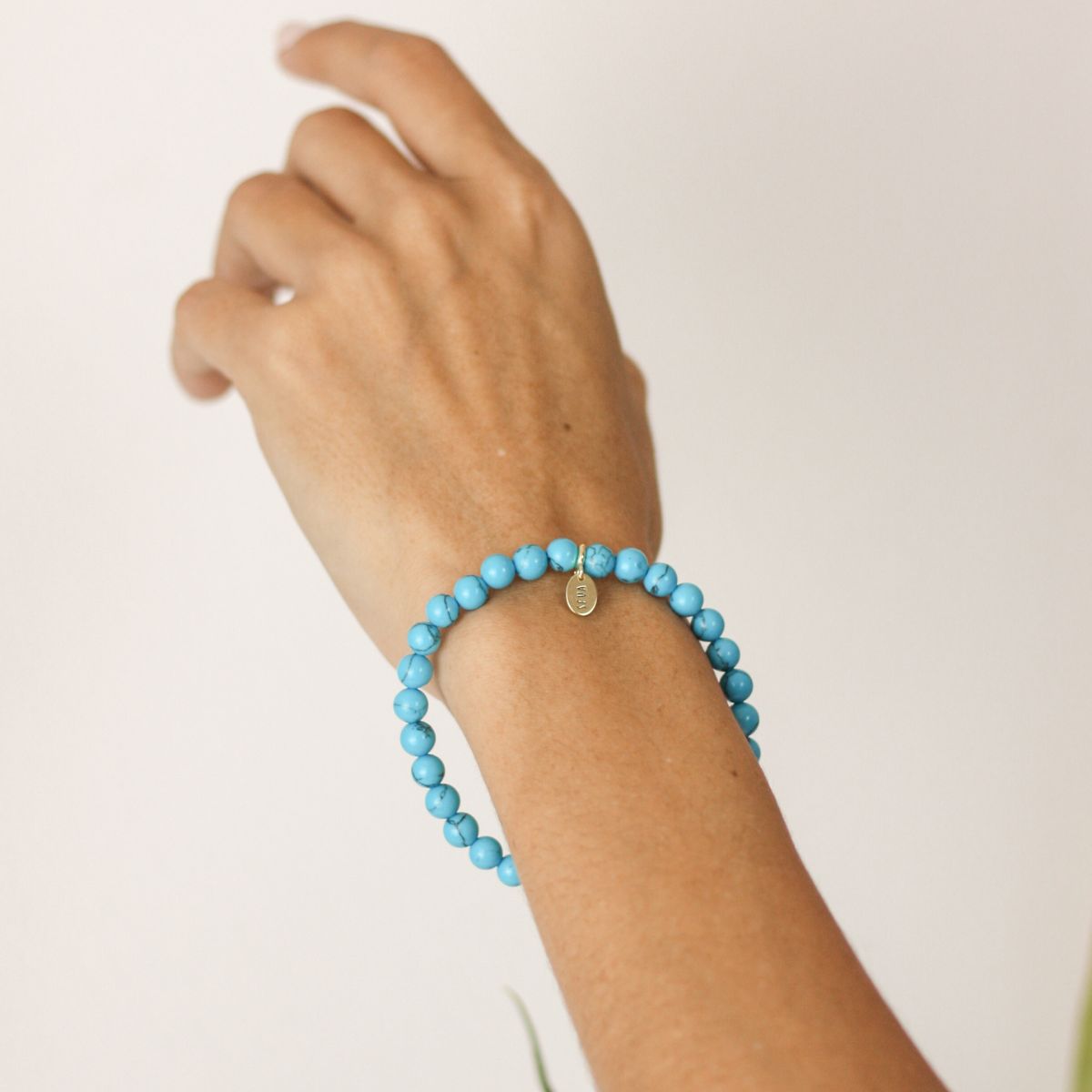 a woman wearing a stone bracelet on her wrist 