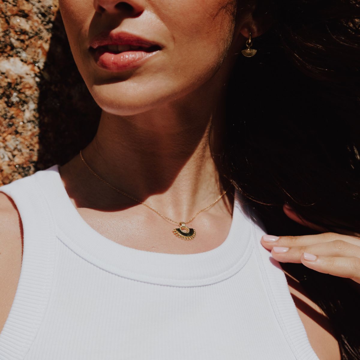 a woman wearing fan shaped necklace and earrings